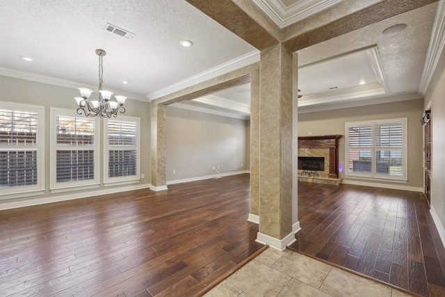 unfurnished living room featuring a high end fireplace, a wealth of natural light, and hardwood / wood-style flooring