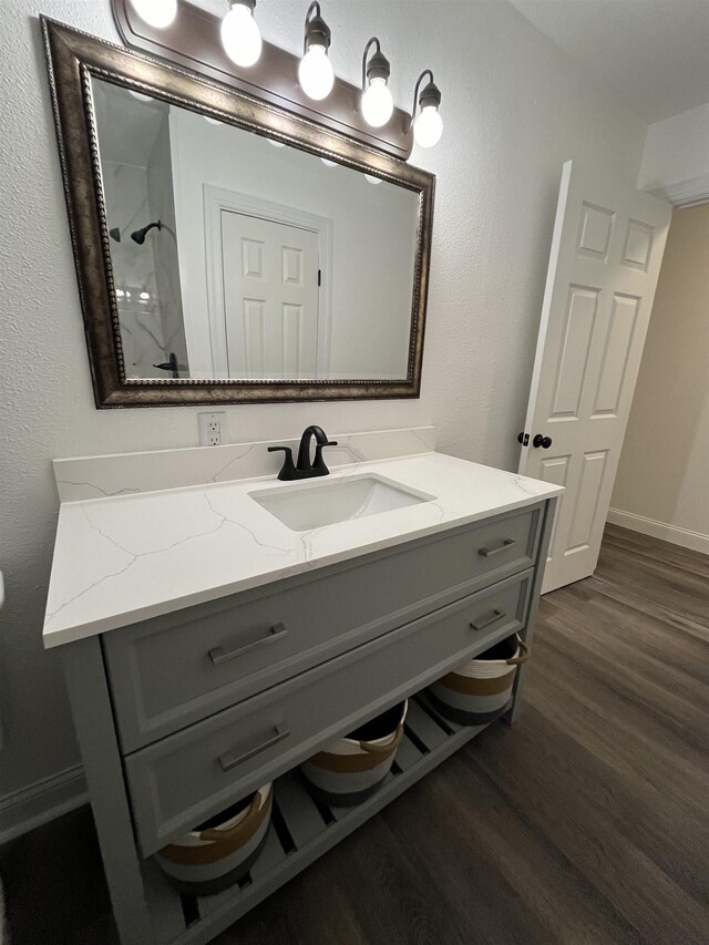 bathroom featuring vanity, hardwood / wood-style flooring, and walk in shower