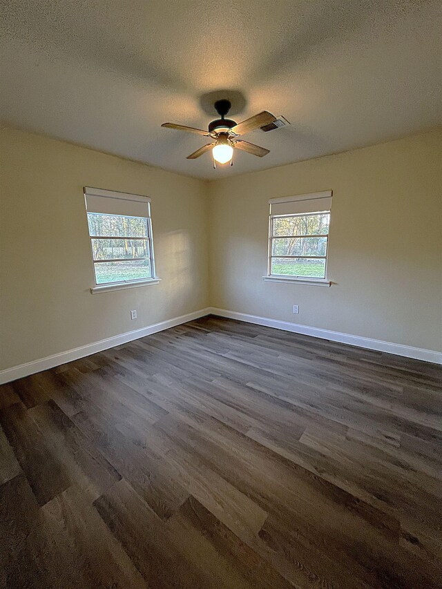 unfurnished room featuring ceiling fan, dark hardwood / wood-style floors, and a textured ceiling