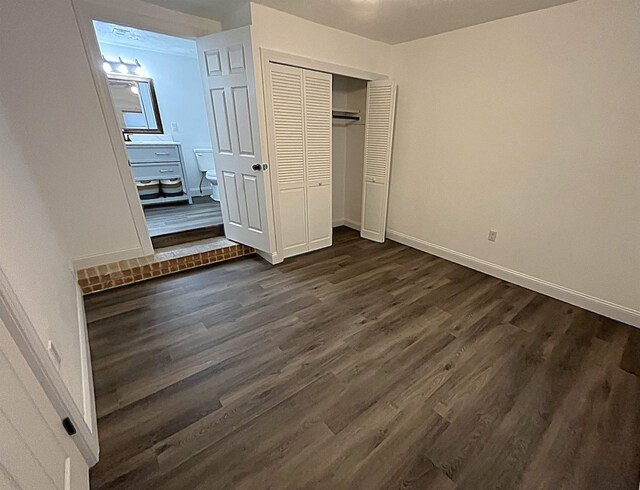 unfurnished bedroom with dark hardwood / wood-style flooring and a closet