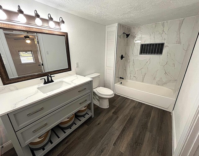 full bathroom with hardwood / wood-style flooring, vanity, a textured ceiling, toilet, and tiled shower / bath