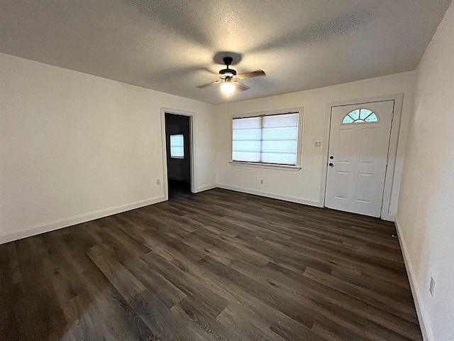 foyer entrance with ceiling fan, dark hardwood / wood-style floors, and a textured ceiling