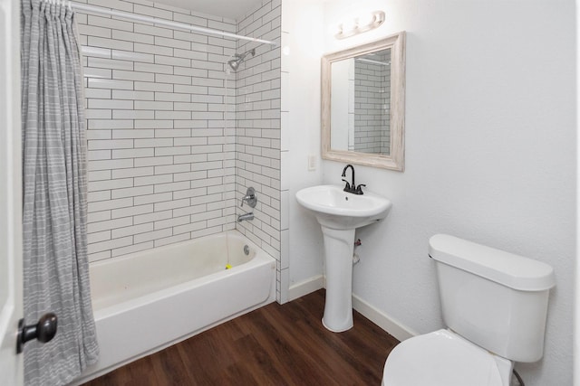 full bathroom featuring sink, hardwood / wood-style flooring, toilet, and shower / bath combo with shower curtain