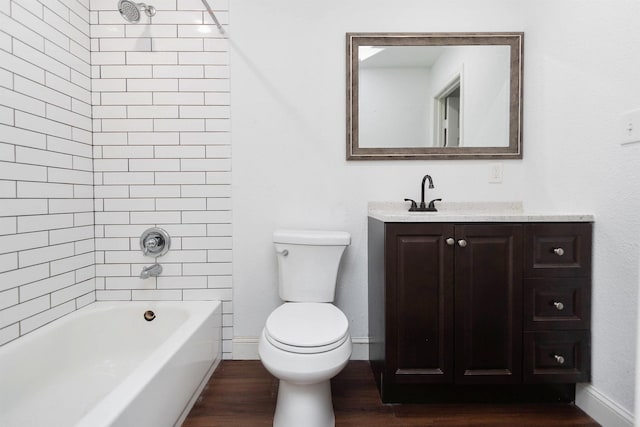 full bathroom with tiled shower / bath combo, vanity, hardwood / wood-style floors, and toilet