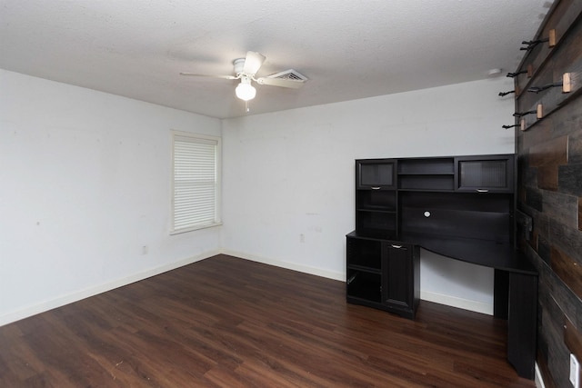 interior space featuring ceiling fan, dark wood-type flooring, and a textured ceiling