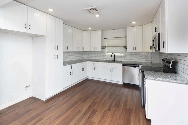 kitchen featuring appliances with stainless steel finishes, sink, decorative backsplash, and white cabinets