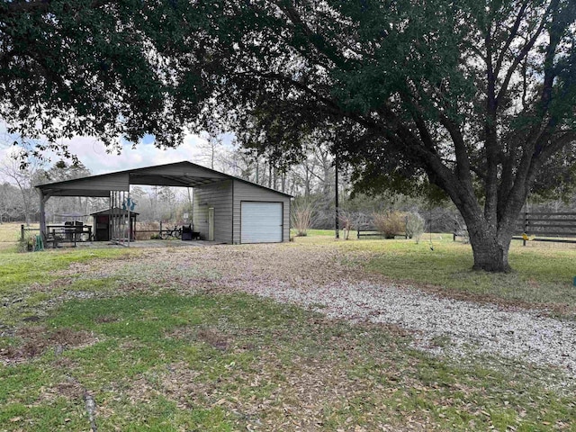 view of yard with a garage, an outbuilding, and fence