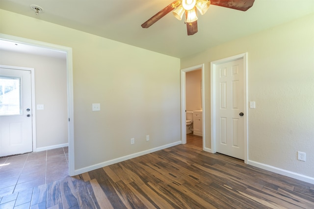 empty room with dark hardwood / wood-style floors and ceiling fan