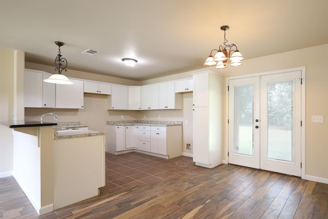 kitchen featuring white cabinets, pendant lighting, and sink