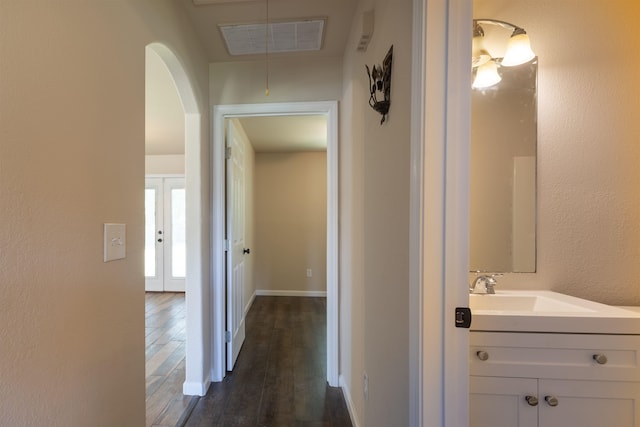 corridor with french doors, dark hardwood / wood-style floors, and sink