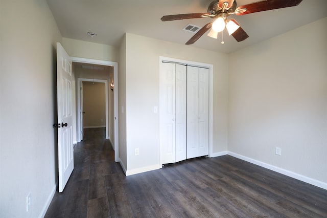 unfurnished bedroom with ceiling fan, dark hardwood / wood-style flooring, and a closet