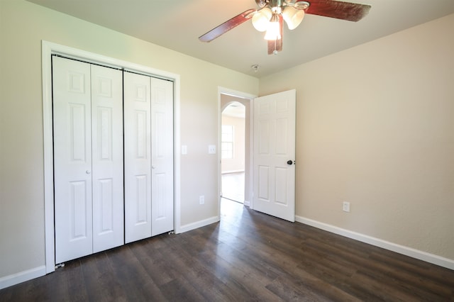 unfurnished bedroom with ceiling fan, dark hardwood / wood-style flooring, and a closet