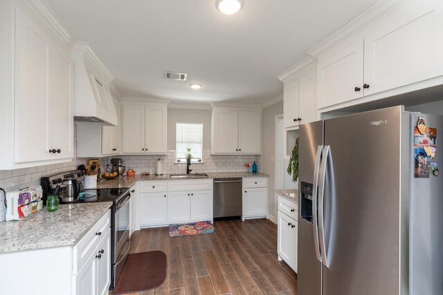 3750 Empire Row, Beaumont, TX 77706 - kitchen featuring appliances with stainless steel finishes, white cabinets, dark wood-style flooring, tasteful backsplash, and custom exhaust hood
