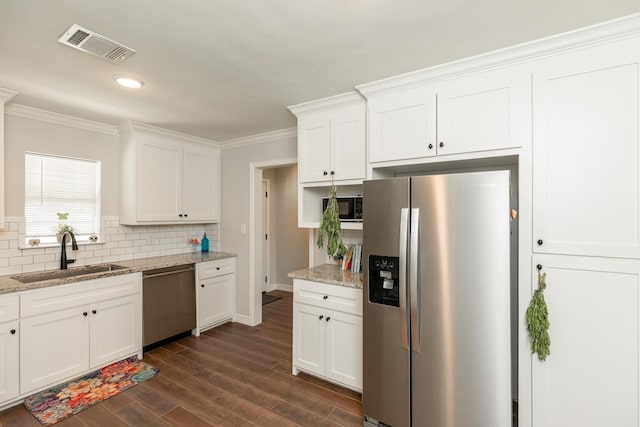 3750 Empire Row, Beaumont, TX 77706 - kitchen featuring appliances with stainless steel finishes, decorative backsplash, crown molding, dark wood-type flooring, and white cabinetry