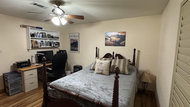 bedroom with a textured ceiling, ceiling fan, and light hardwood / wood-style flooring