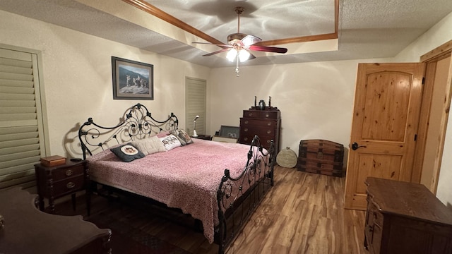 bedroom featuring ceiling fan, a textured ceiling, and hardwood / wood-style floors