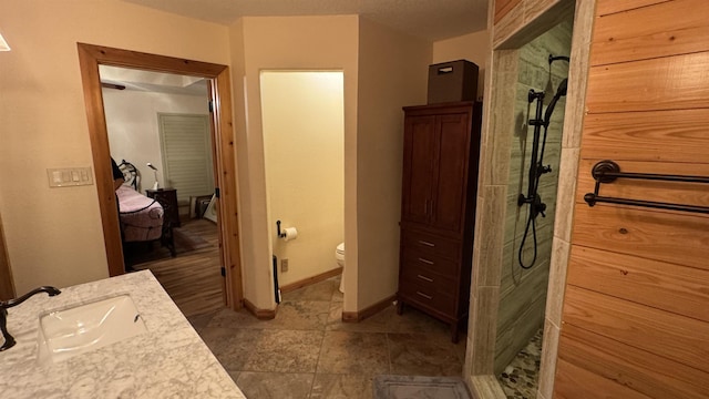 bathroom with toilet, a shower, and vanity