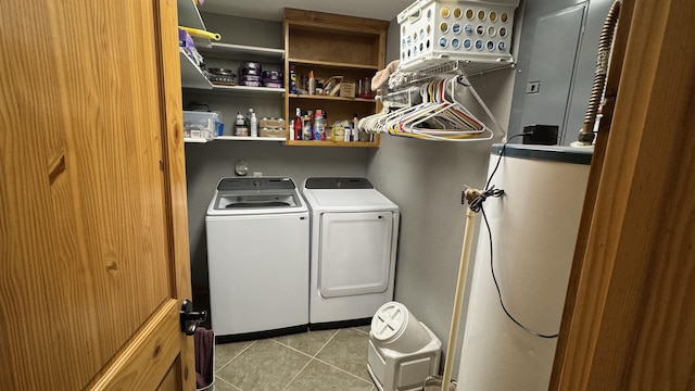 clothes washing area featuring light tile patterned floors, gas water heater, and independent washer and dryer