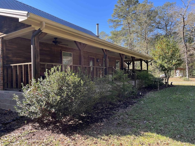 view of home's exterior featuring ceiling fan and a yard