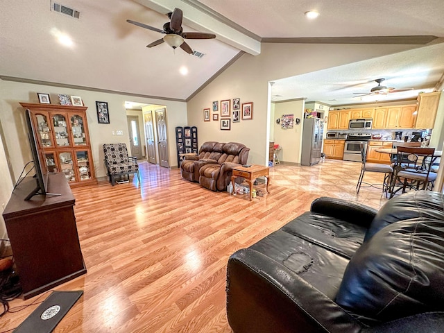 living room featuring vaulted ceiling with beams, light hardwood / wood-style floors, a textured ceiling, and ceiling fan