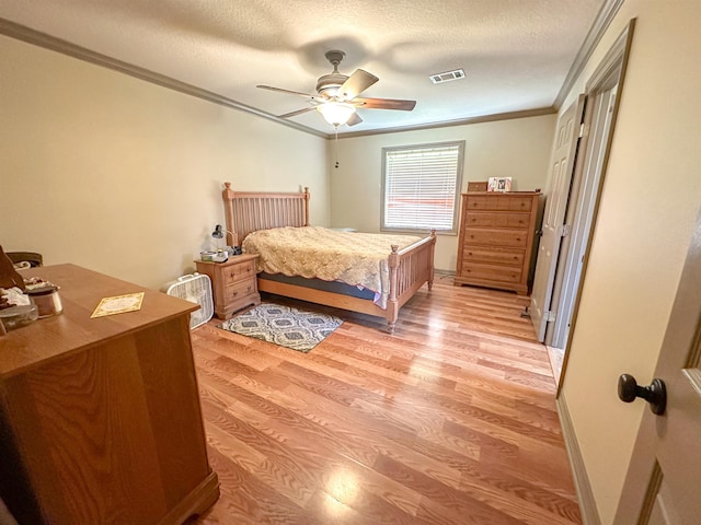 bedroom with ceiling fan, crown molding, a textured ceiling, and light wood-type flooring