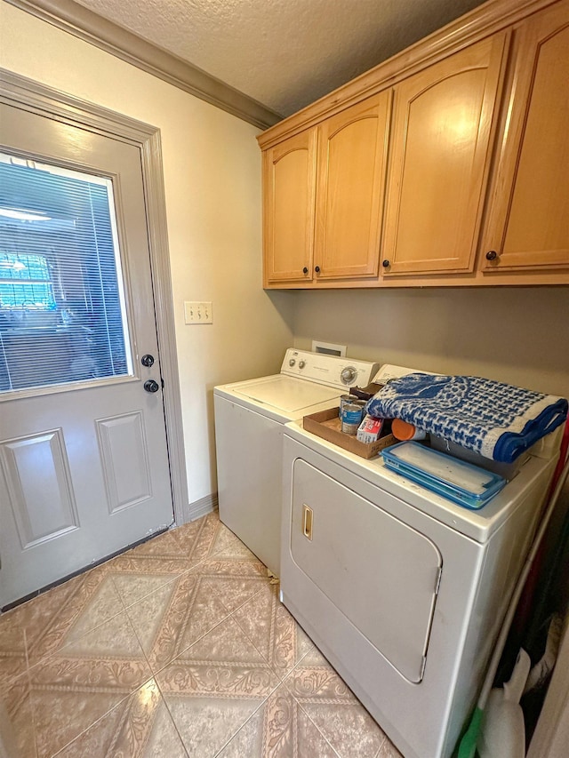 laundry area with ornamental molding, cabinets, a textured ceiling, and independent washer and dryer