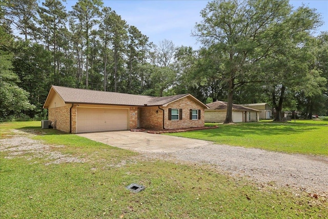 1663 Bluebonnet St, Vidor, TX 77662 - view of front of house with central AC unit, driveway, an attached garage, brick siding, and a front yard