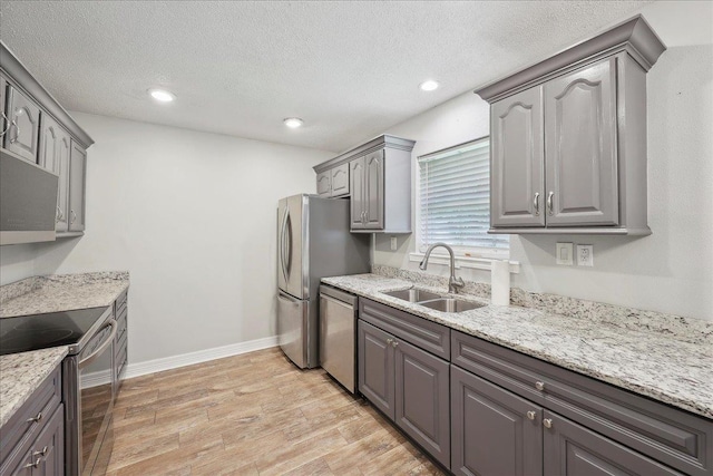 1663 Bluebonnet St, Vidor, TX 77662 - kitchen with a sink, appliances with stainless steel finishes, light wood-style floors, gray cabinetry, and recessed lighting
