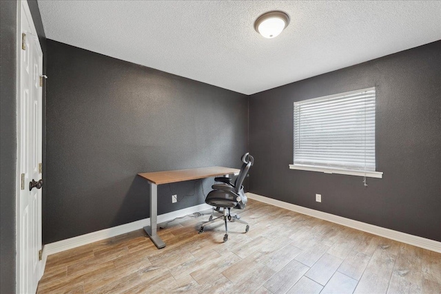 1663 Bluebonnet St, Vidor, TX 77662 - home office with light wood-type flooring, a textured ceiling, and baseboards