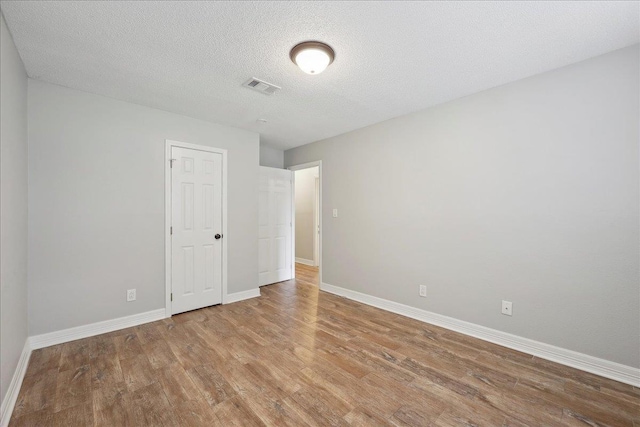 1663 Bluebonnet St, Vidor, TX 77662 - unfurnished bedroom with wood finished floors, baseboards, and a textured ceiling