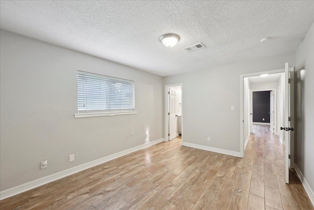 1663 Bluebonnet St, Vidor, TX 77662 - unfurnished room featuring light wood-type flooring, baseboards, and a textured ceiling