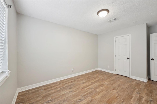 1663 Bluebonnet St, Vidor, TX 77662 - spare room featuring light wood-style floors, baseboards, and a textured ceiling