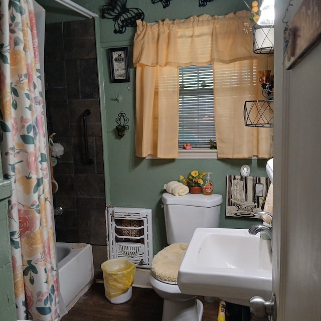 bathroom with shower / bath combo, wood finished floors, a sink, toilet, and heating unit