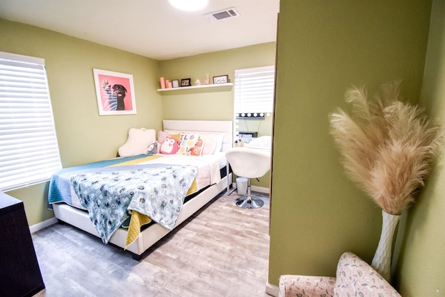 bedroom featuring wood-type flooring and multiple windows