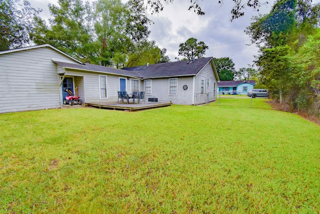 rear view of property featuring a deck and a yard