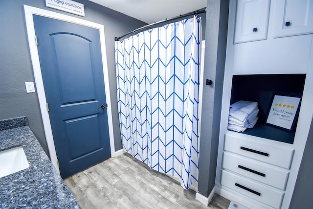 bathroom with curtained shower, vanity, and hardwood / wood-style flooring