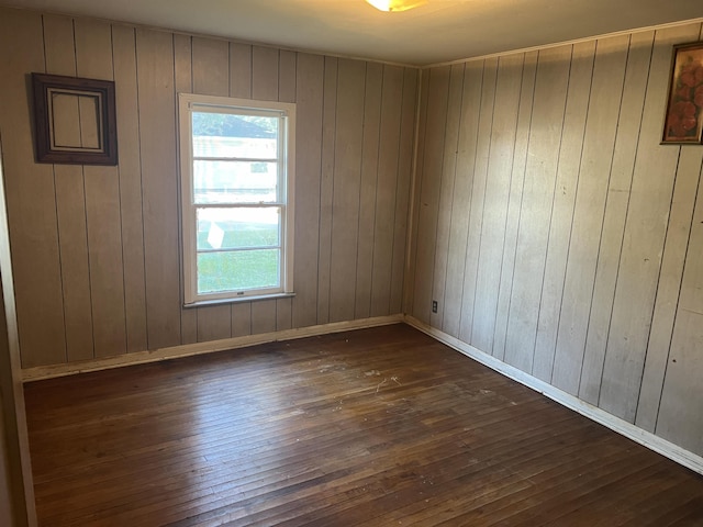 empty room with wood walls and dark hardwood / wood-style floors