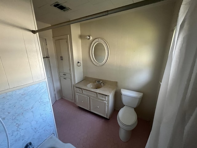 bathroom featuring vanity, toilet, and walk in shower