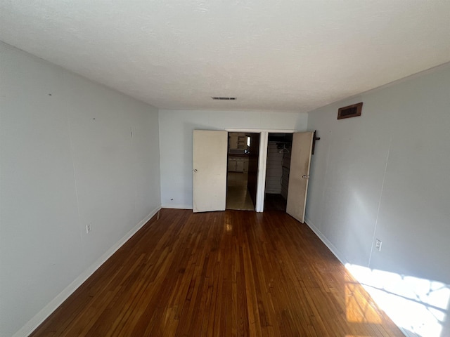 unfurnished room with dark hardwood / wood-style flooring