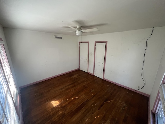 unfurnished bedroom featuring ceiling fan and dark wood-type flooring