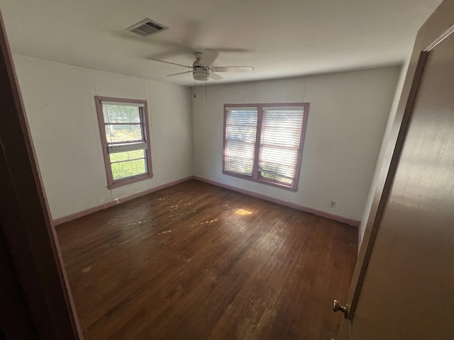 unfurnished room with ceiling fan and dark wood-type flooring