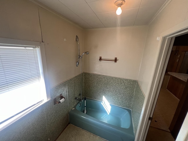 bathroom with a bath, ornamental molding, and sink