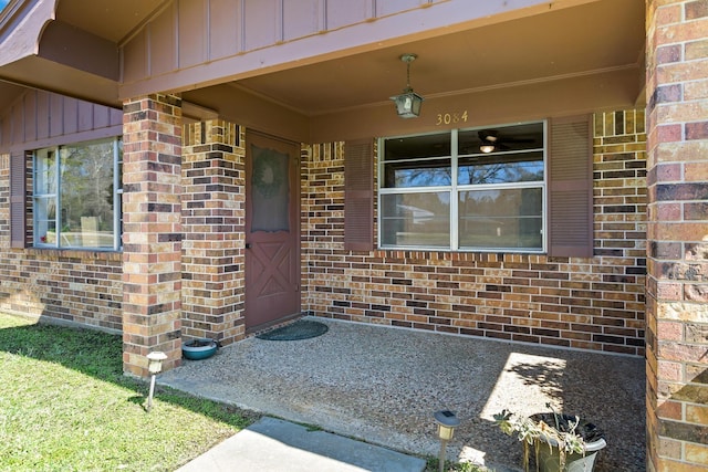 view of exterior entry with brick siding and board and batten siding