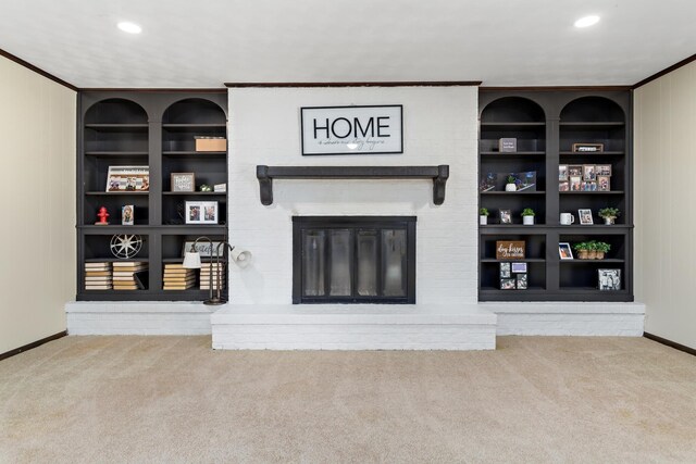 carpeted living room with built in features, a fireplace, baseboards, and ornamental molding