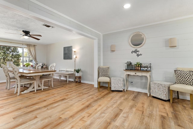 dining space with visible vents, baseboards, ceiling fan, wood finished floors, and a textured ceiling