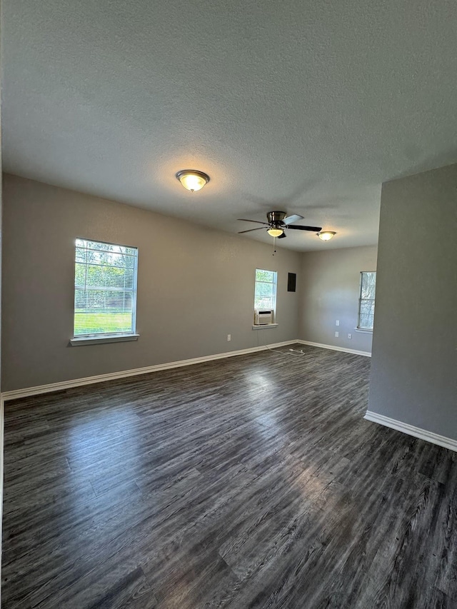 empty room featuring ceiling fan, dark hardwood / wood-style flooring, and a textured ceiling