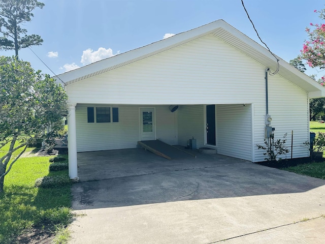 8594 Morgan Ln, Orange, TX 77632 - view of property exterior featuring concrete driveway, a carport, and a lawn