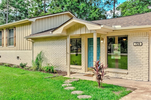 view of exterior entry featuring a lawn