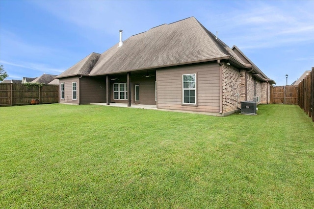 rear view of property with a yard and cooling unit