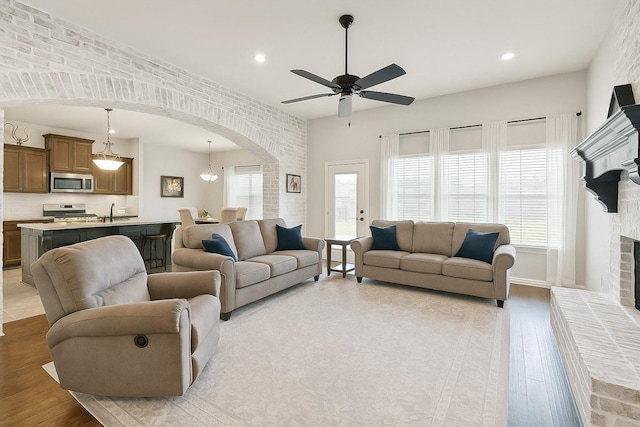 1390 Kalas Cir, Lumberton, TX 77657 - living area featuring arched walkways, light wood-style floors, a ceiling fan, recessed lighting, and a fireplace